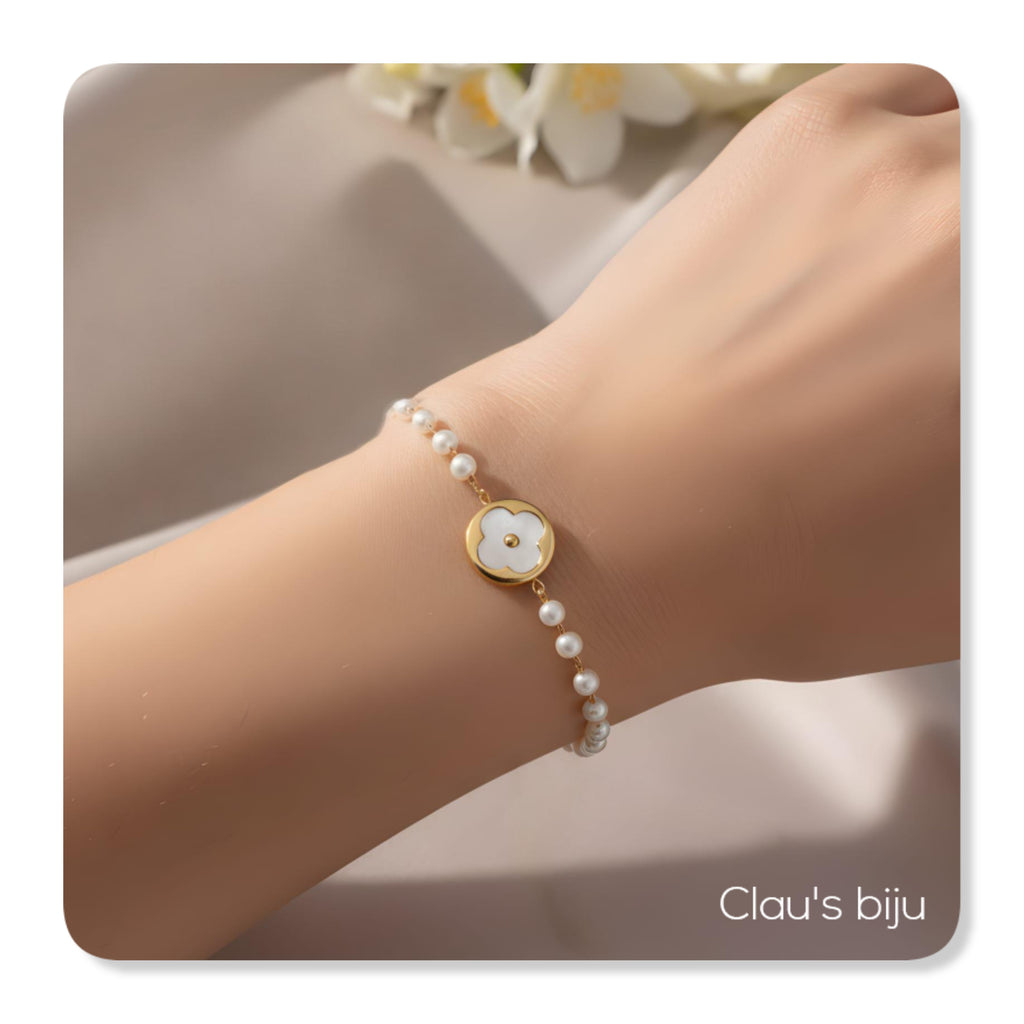 Bracelet en acier inoxydable orné de perles et d'un centre en nacre.