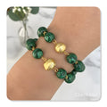 Bracelets with Malachite stones and 18-karat gold-plated pieces.