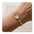Stainless steel bracelet with pearls and mother-of-pearl centerpiece.